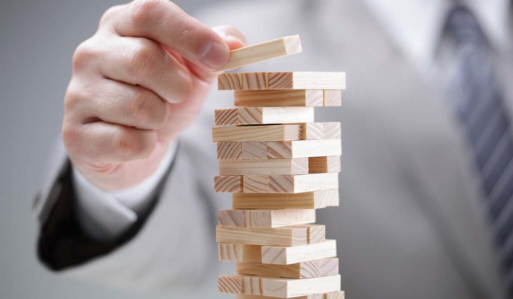 close-up of jenga game with businessman in background