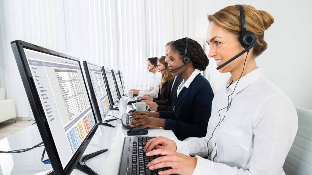 Bank of customer service agents with headsets helping customers