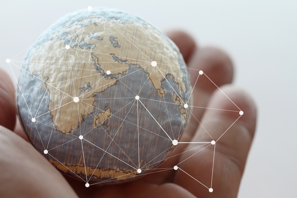 hand holding globe with network graphic superimposed