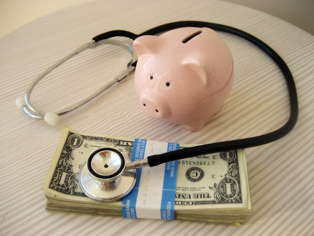 piggy bank with stethoscope and money