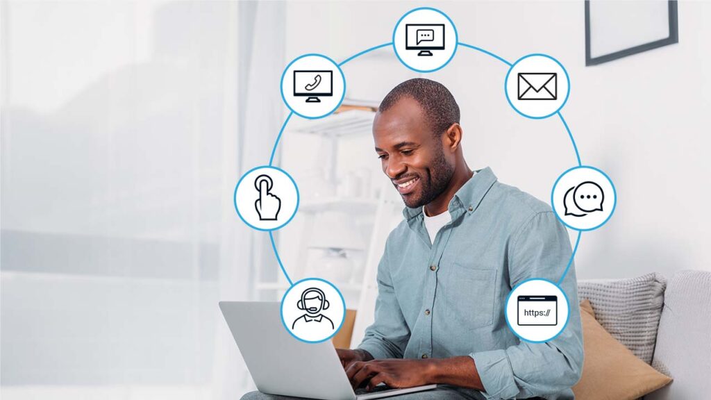 smiling man using laptop, surrounded by communication channel icons
