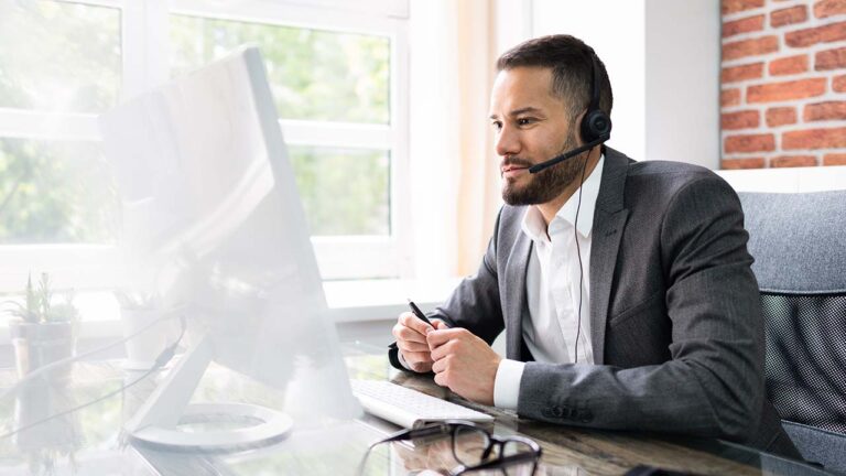 Contact center agent wearing headset at desk with computer